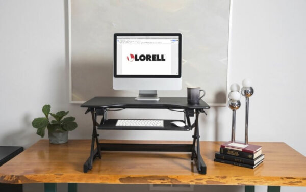 Lorell LLR81974 monitor riser sitting on wood desk with monitor and coffee cup