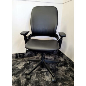 Steelcase Leap V2, Black frame; reupholstered in black vinyl, Upper back force, 5" pneumatic seat-height adjustment, Variable backstop, Lower back firmness, Rectilinear independent height-, width-, pivot-, and depth- adjustable arms and soft arm caps, 3" seat depth adjustment, Passive seat edge angle, Adjustable lumbar, 2 1⁄2"-diameter, hard-composition, dual-wheel casters