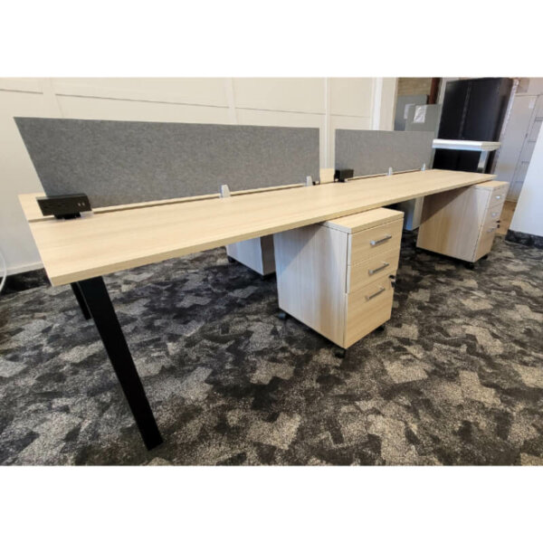 Ionic 48" x 120" Quad Benching Workstation Four-pack dual-sided table desks, overall 50.4"D x 120"L x 29"H Includes: (4) Mobile box/box/file pedestals, (4) clamp-on power modules, privacy panels, cable management tray  Surface Laminate: Nocce Leggero H-leg Finish: Black Kits include four 24"D tops, two double wide end H-legs, one double wide middle H-leg and top supports for end-to-shared middle leg conditions 1" thick thermally fused laminate tops with matching 2mm edge Double wide H-legs constructed of 2" steel tube legs with 1"x 2" cross bar and include adjustable leveling glides Legs powder-coat painted in a durable sandtex finish. 2.5" centre gap runs parallel and between top surfaces to accept privacy screens or manage cables for the desktop Use alone as a four-station cluster or can be used with 62.4" extender tables (MLxx62DSE) installed in the middle position to extend the overall length Meets all applicable ANSI/BIFMA standards 